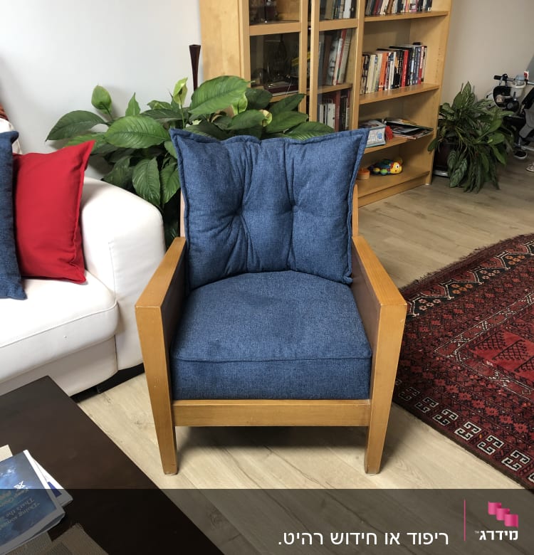 כורסה עם ריפוד כחול על רצפת עץ